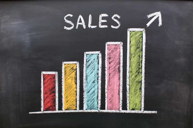 Hand-drawn colorful bar chart showing sales growth on a blackboard