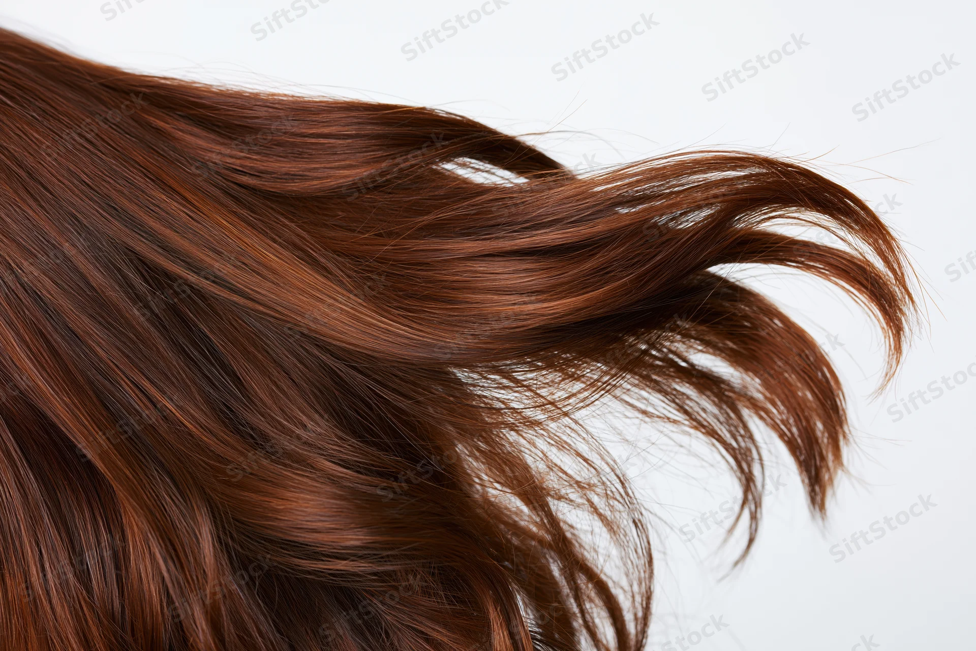 Long brown wavy hair flowing in motion against white background