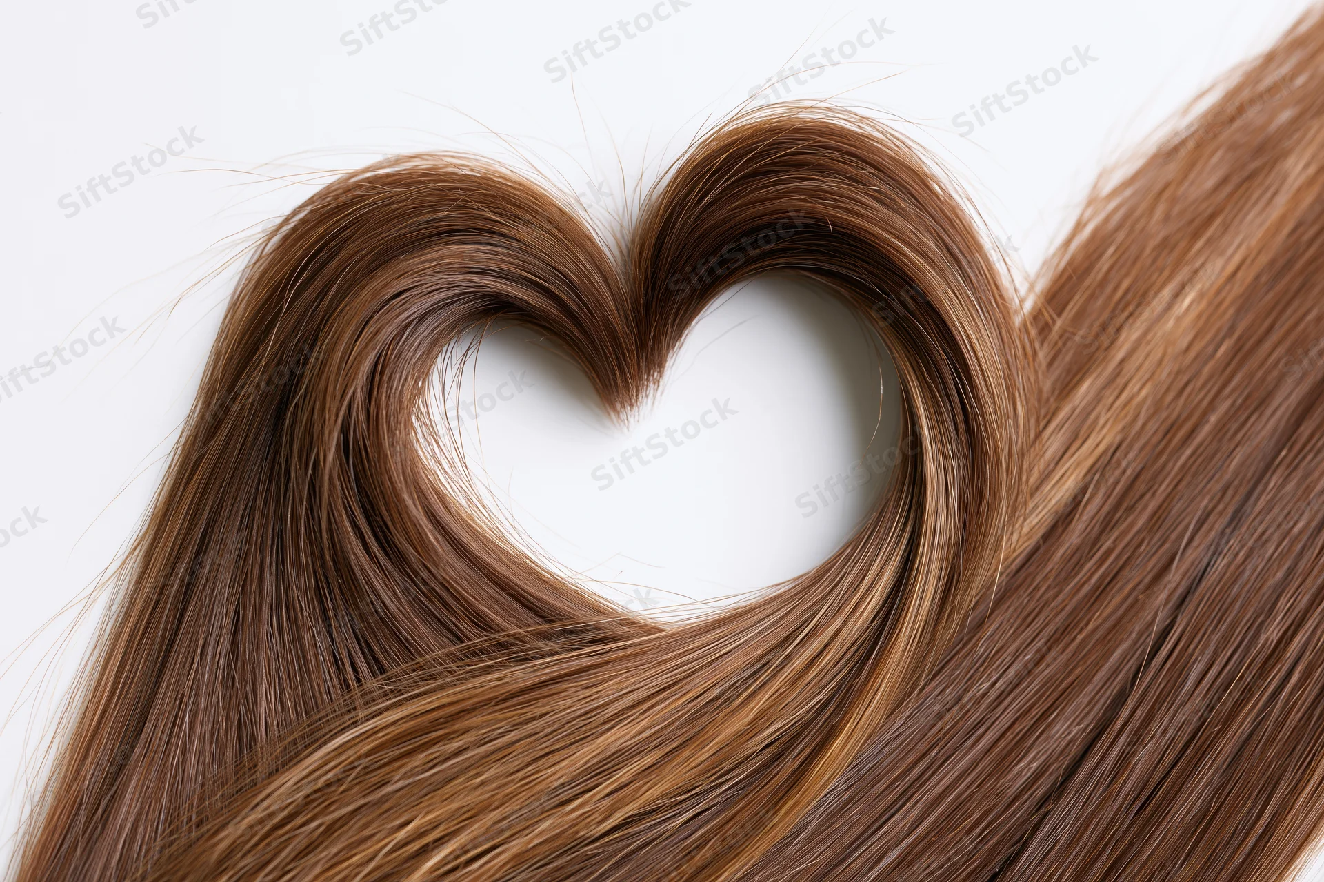 Long glossy brown hair arranged in a heart shape against a white background