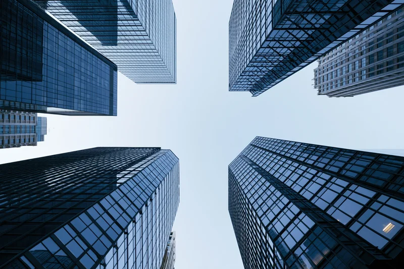 Low-angle view of glass skyscrapers rising into the sky in a dense city center