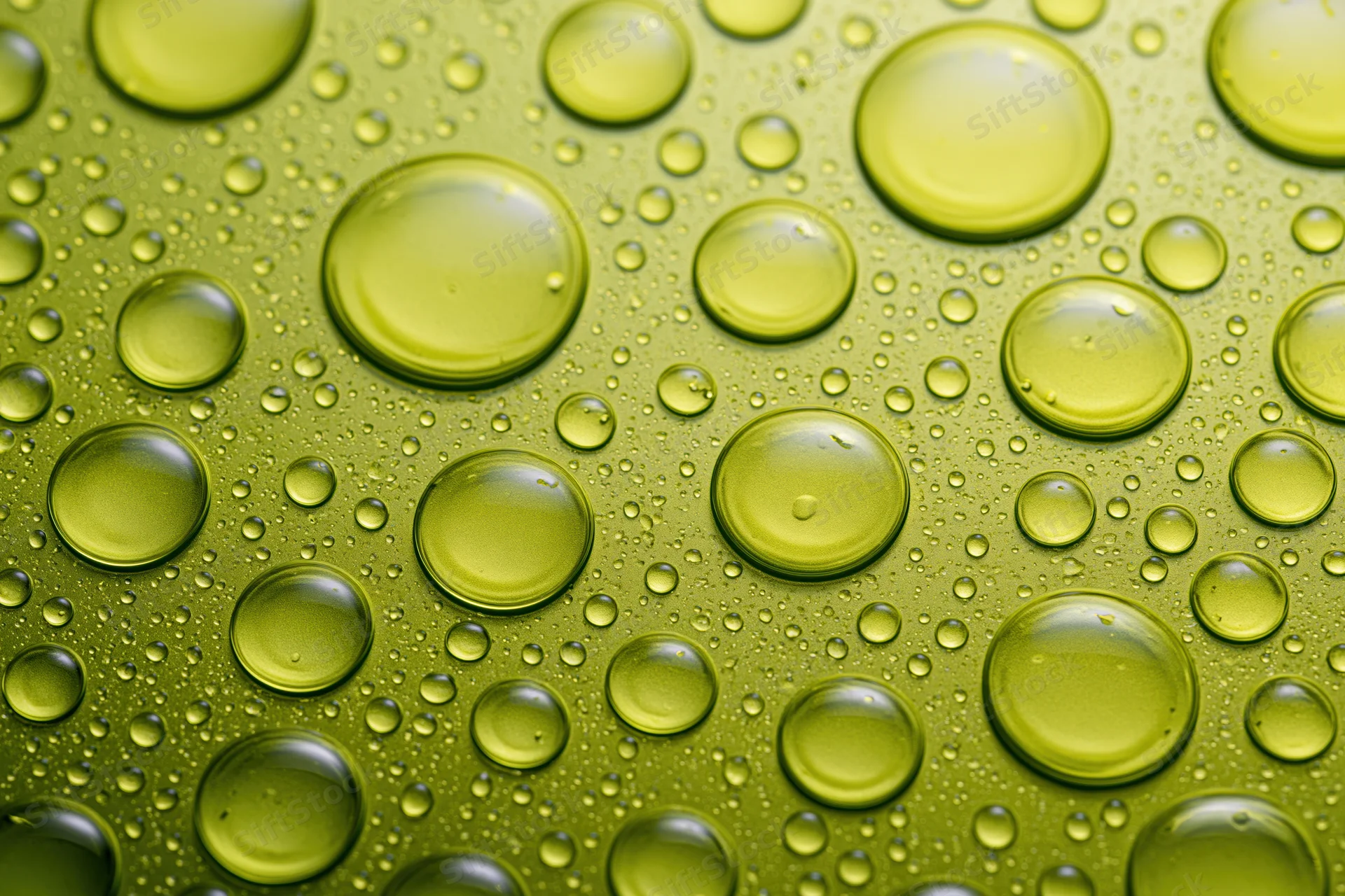 Macro closeup of scattered oil droplets on a green glossy surface