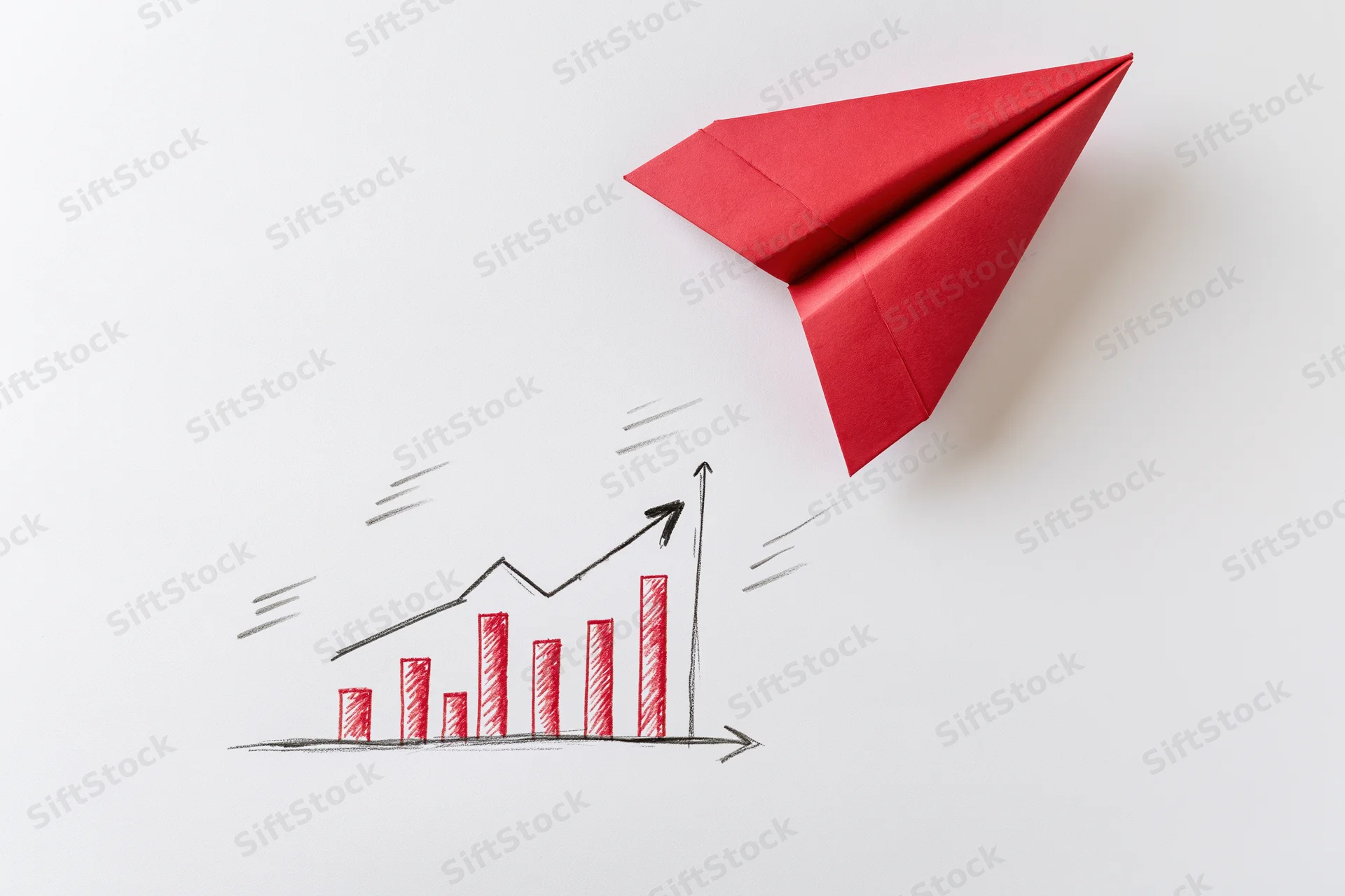 Red origami paper airplane flying over a hand-drawn upward trending bar graph on white surface