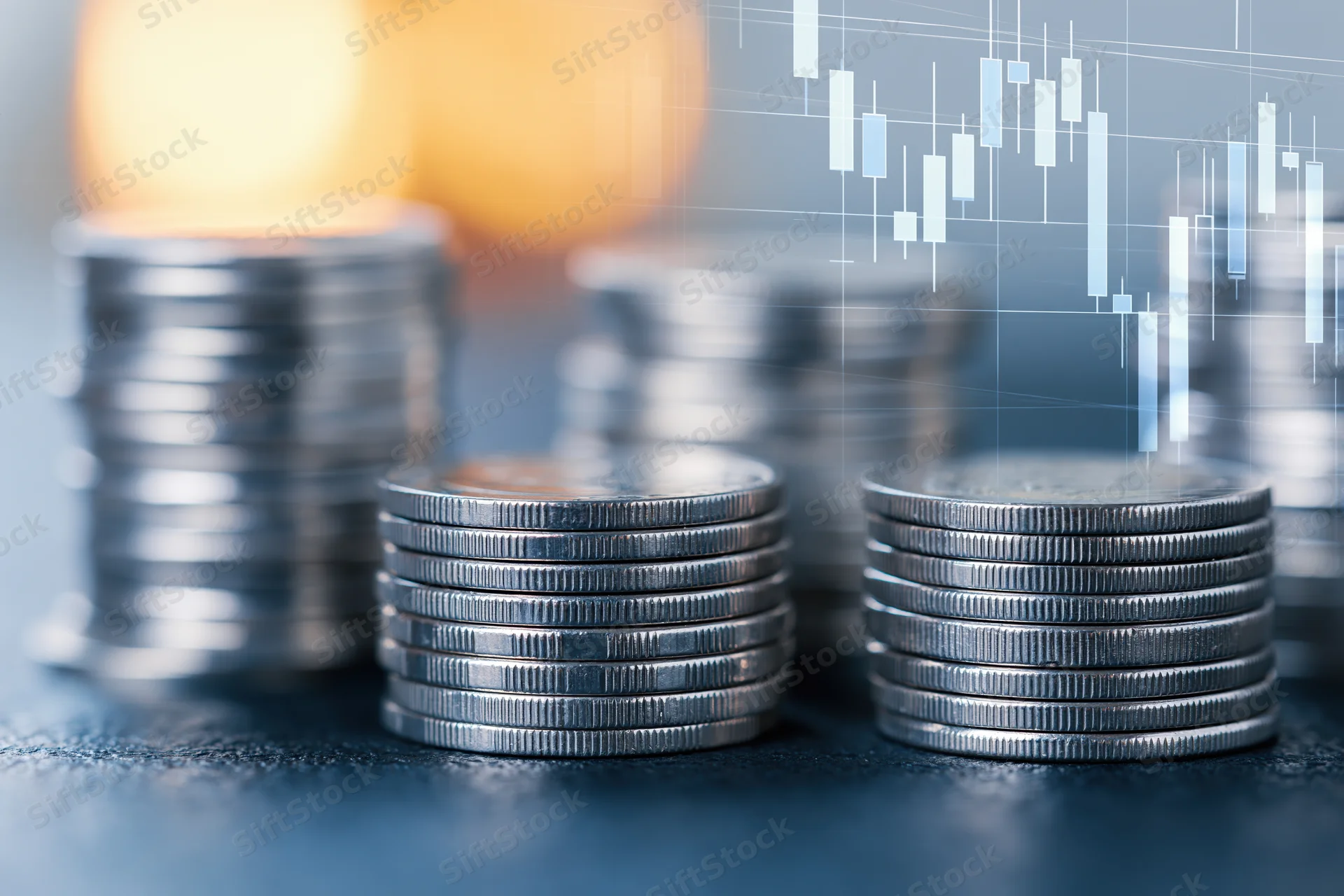 Stacks of silver coins on a dark surface with a digital candlestick chart overlay