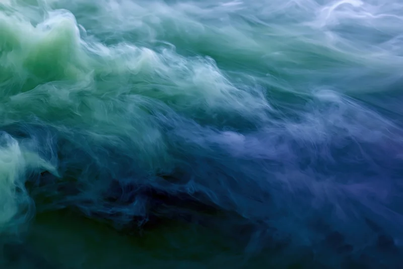 Swirling ink clouds dispersing in water in a full-frame macro abstract view