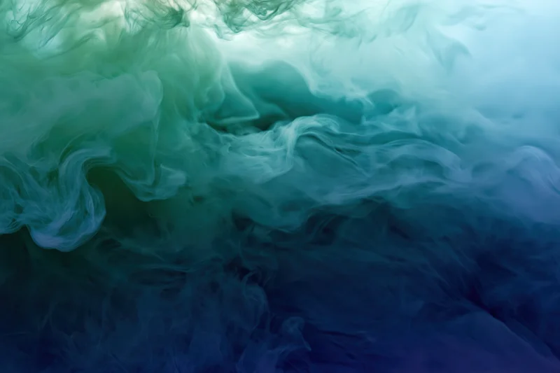 Swirling ink clouds dispersing in water full frame macro abstract