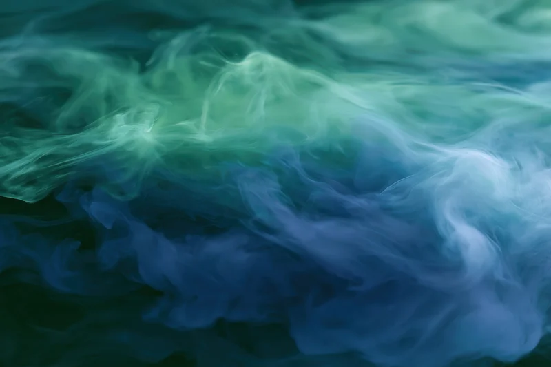 Swirling ink clouds dispersing in water full frame macro abstract