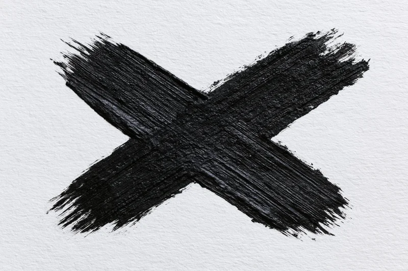 Bold hand-painted black x mark on textured white paper