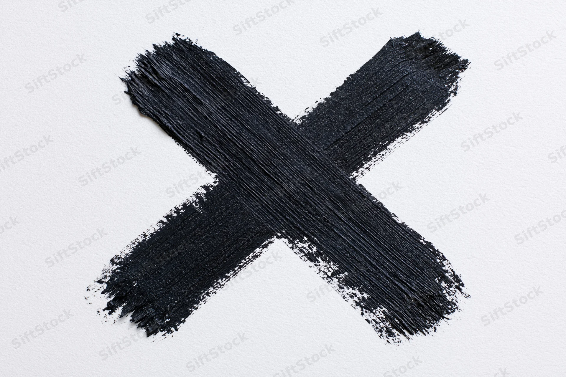 Bold hand-painted black x mark on white surface