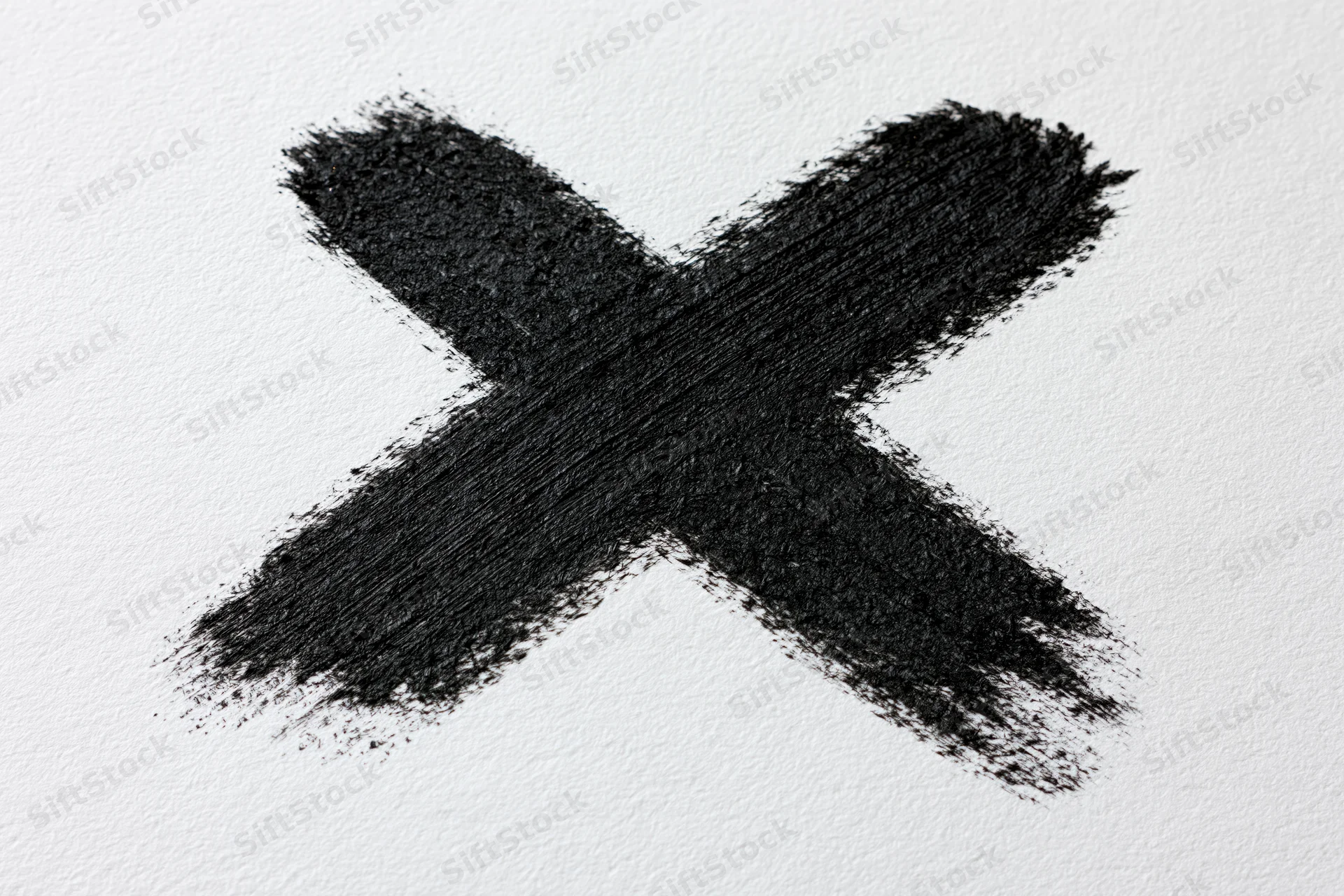 Bold hand-painted black x mark on textured white paper