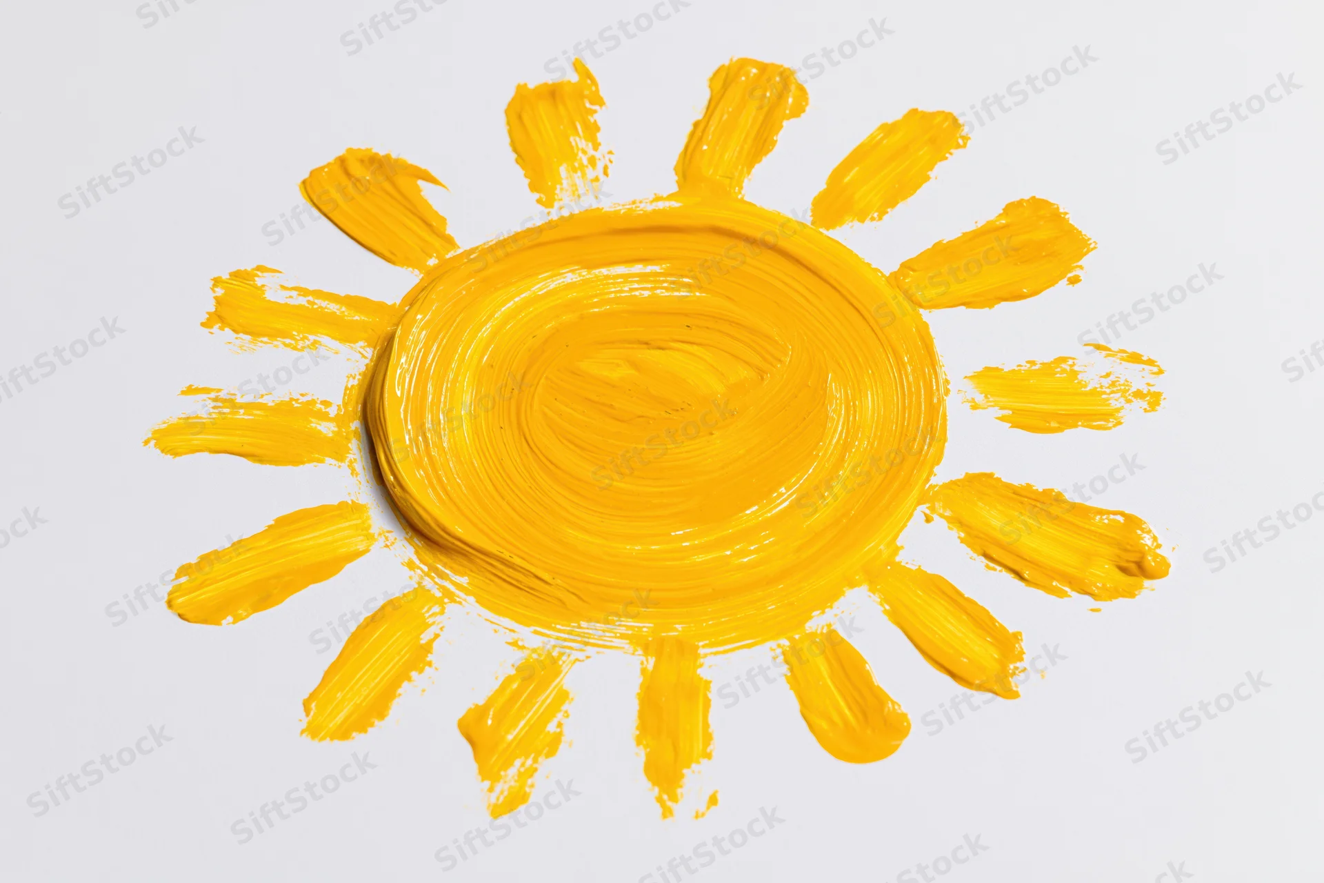 Hand-painted sun drawing on white paper with yellow paint strokes radiating from circular center