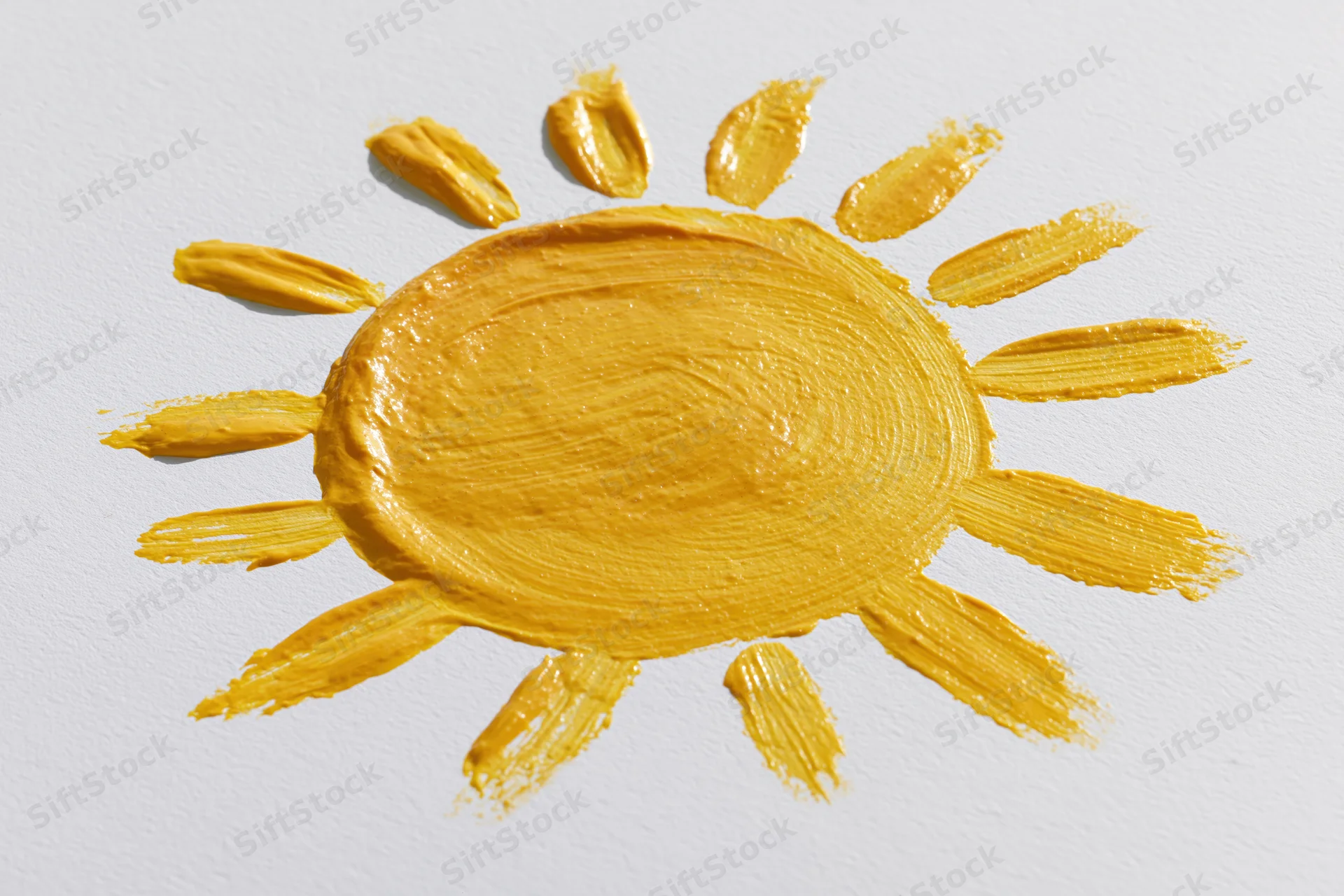 Hand-painted sun drawing on white paper with textured yellow paint strokes