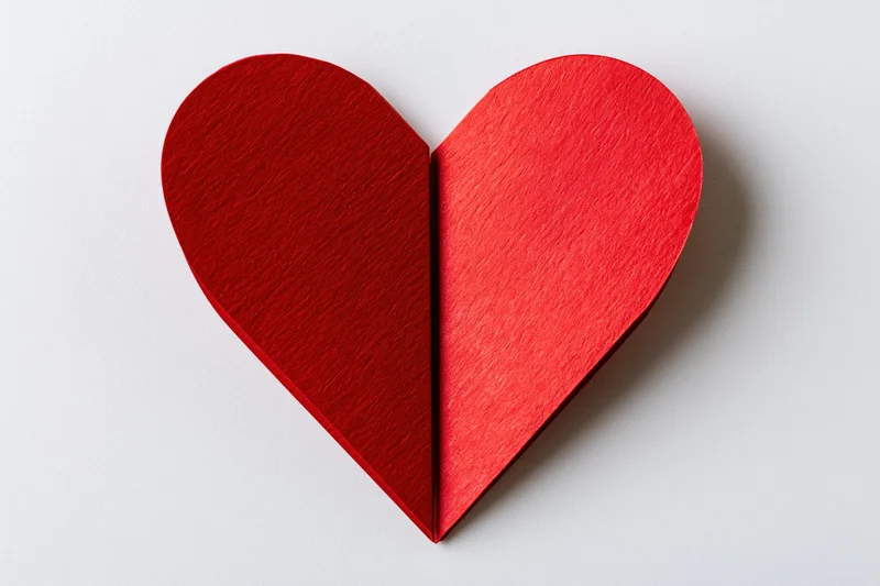 Folded red paper heart centered on white background