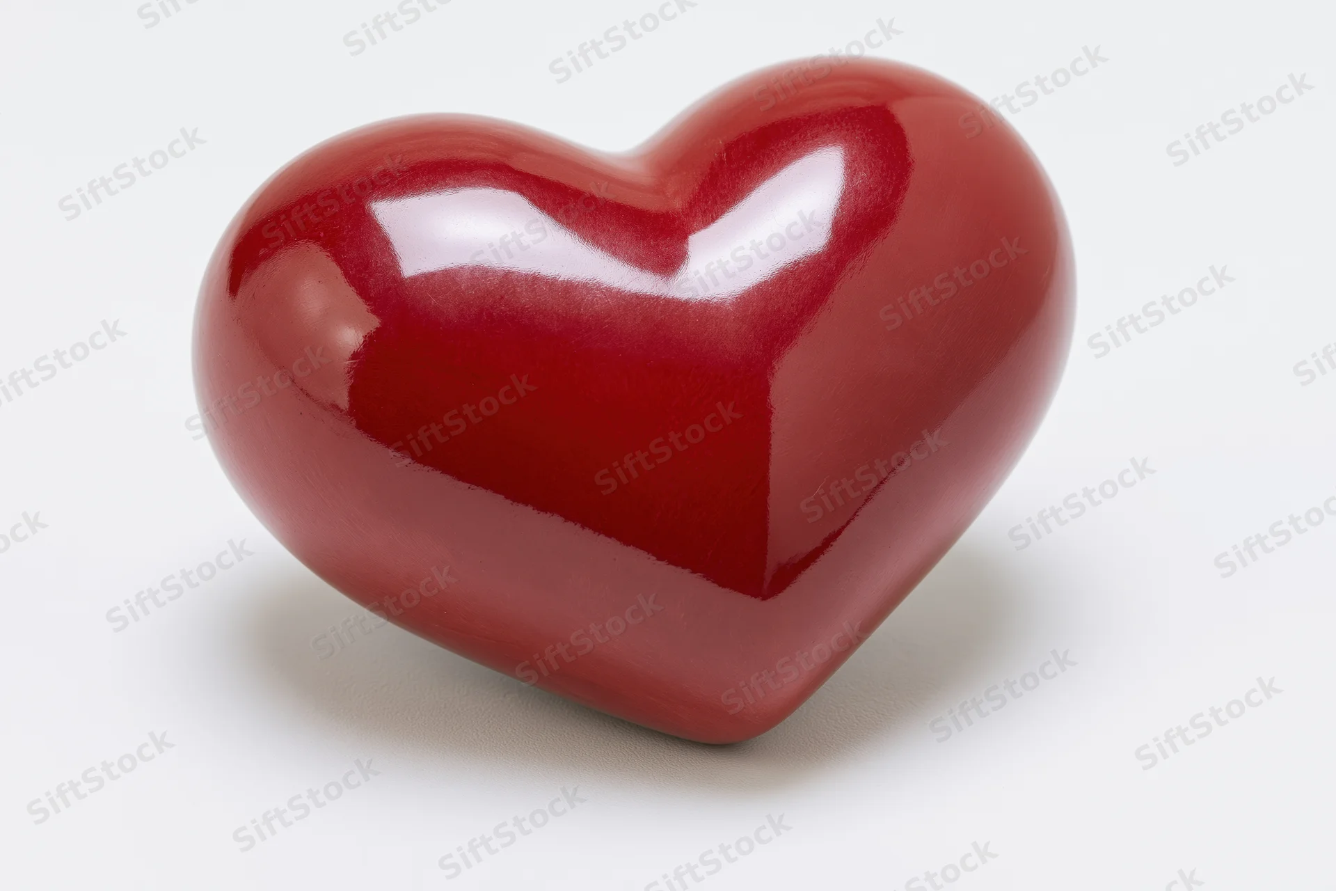 Glossy red ceramic heart object isolated on white background
