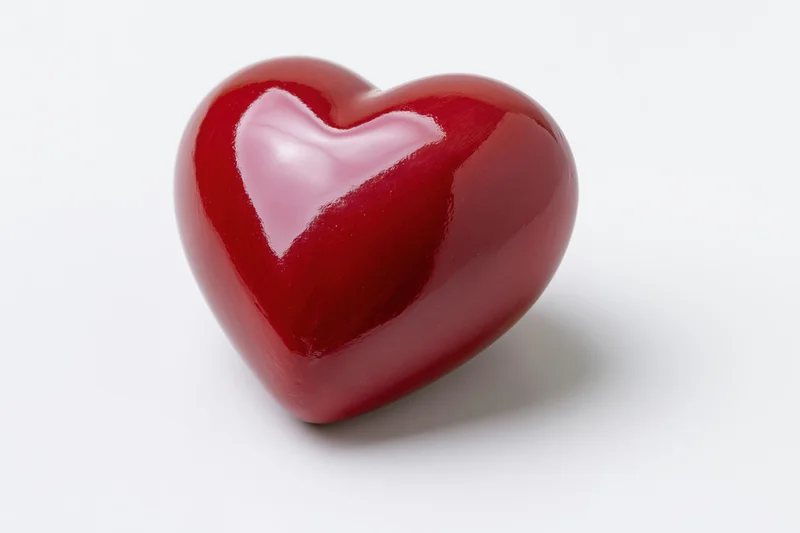 Glossy red ceramic heart-shaped object centered on white background
