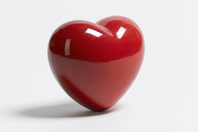 Glossy red heart-shaped object centered on white background