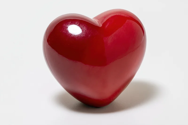 Glossy red heart-shaped object centered on white background