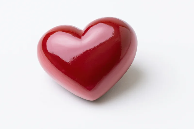 Glossy red heart-shaped object centered on a pure white background