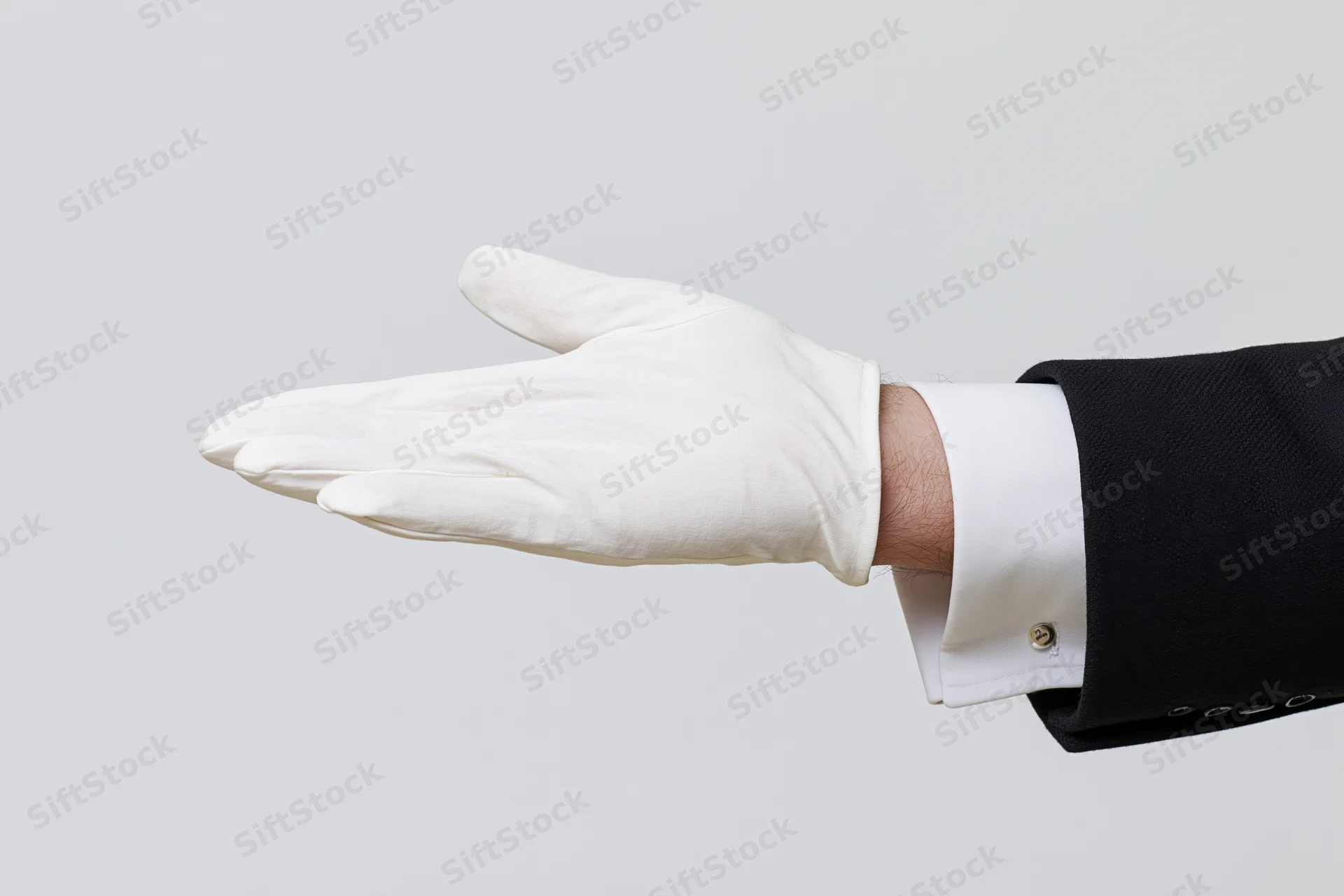 Hand in white glove extended palm-up in offering gesture against plain background