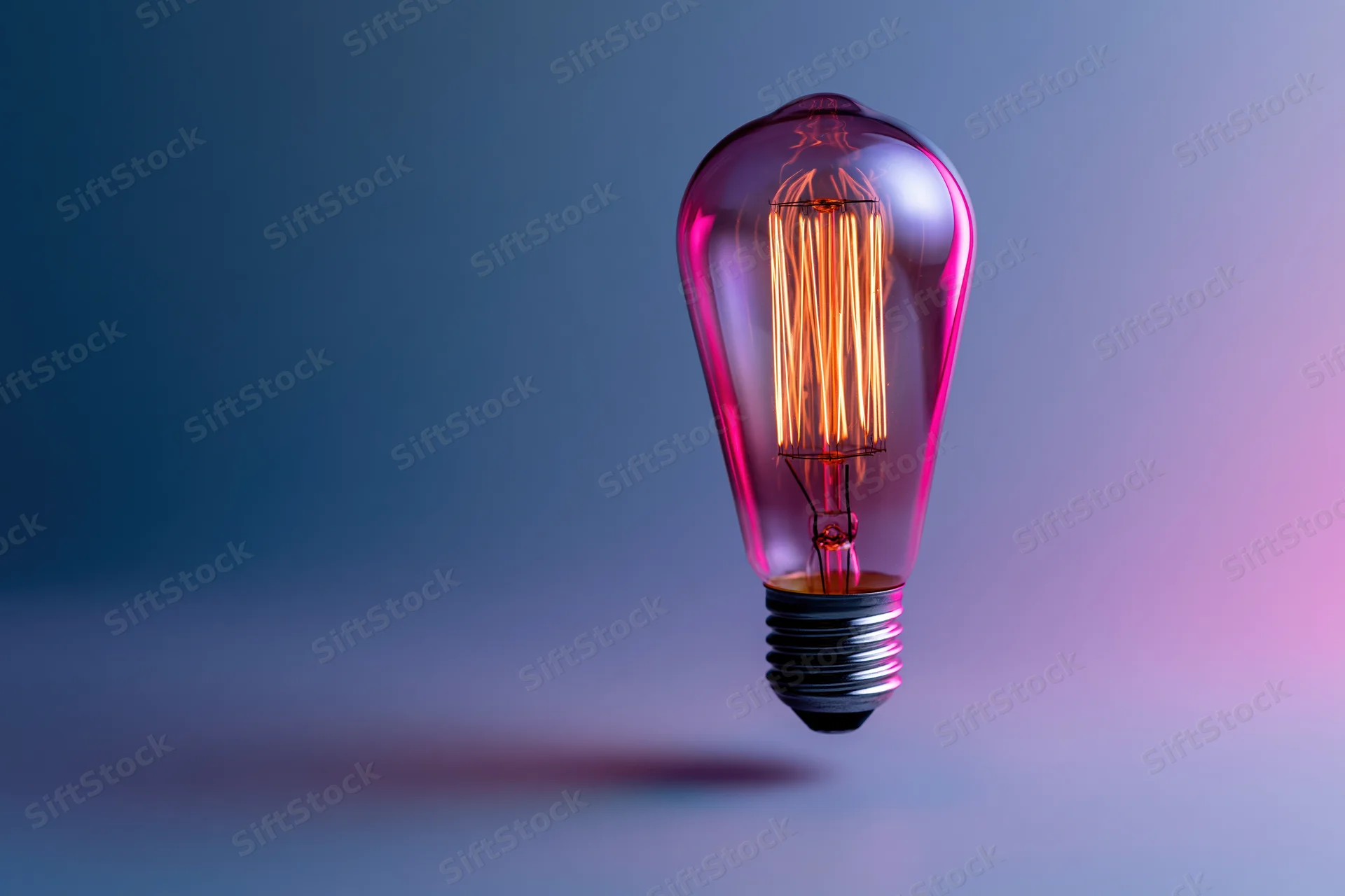 Glowing edison filament lightbulb floating against a gradient background with copyspace