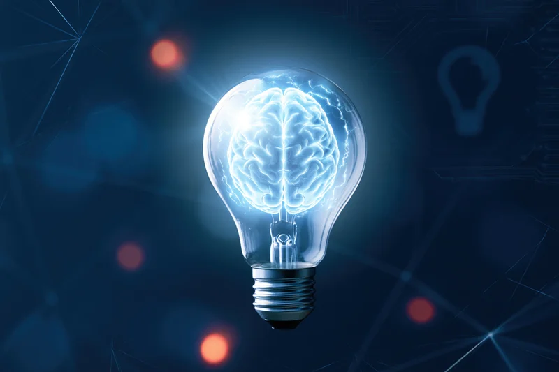 Glowing lightbulb containing a luminous brain illustration against a digital network background