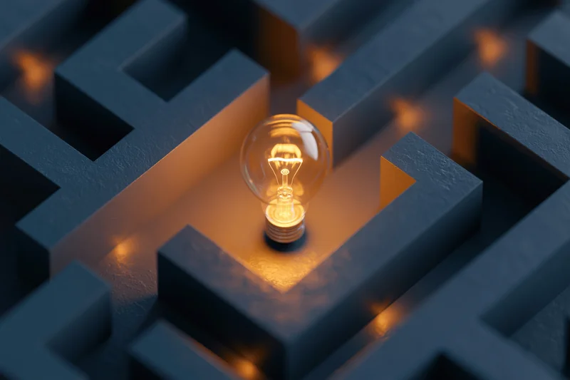 Glowing lightbulb at center of dark maze structure