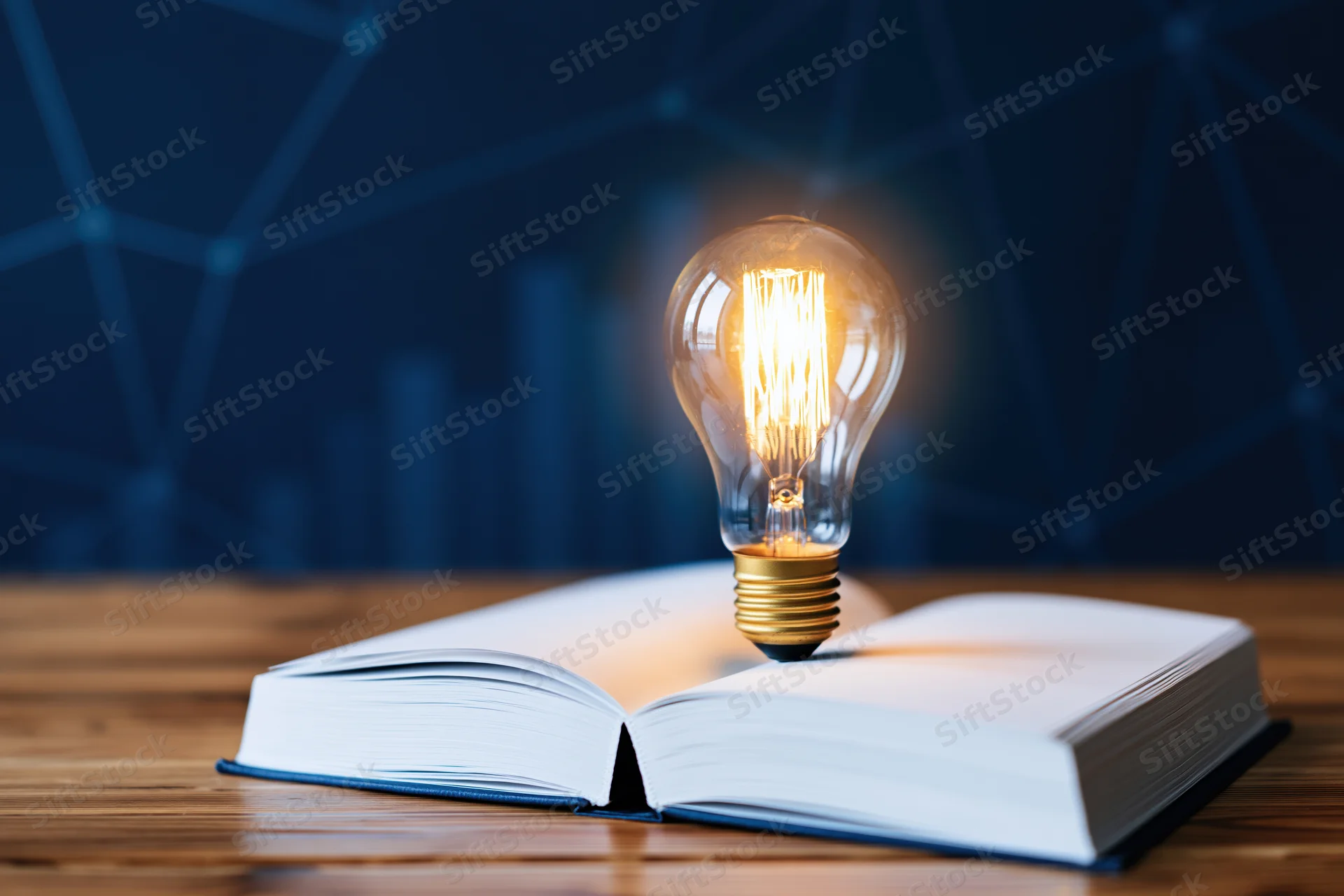Glowing incandescent lightbulb resting on open book on wooden table with digital network background