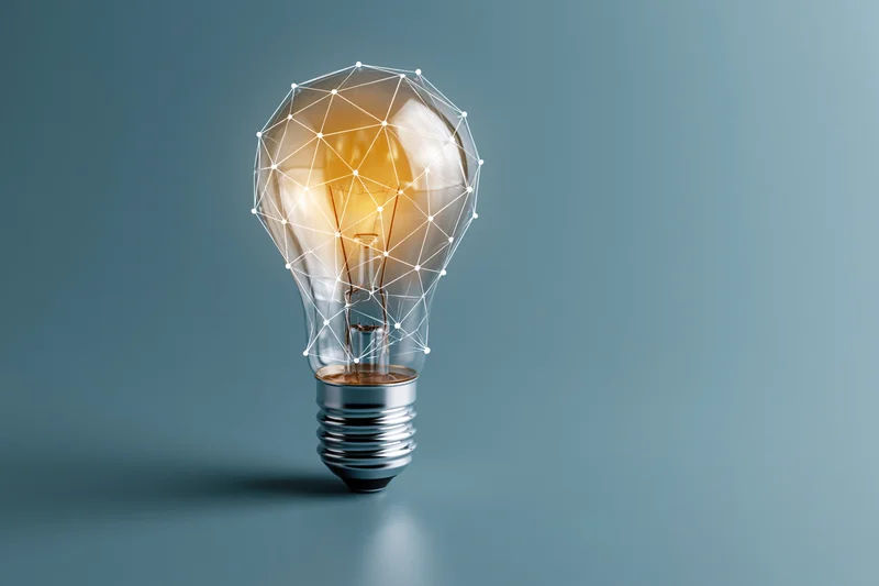Glowing incandescent light bulb with geometric wireframe overlay on blue gradient background