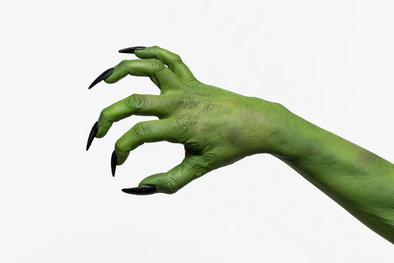 Green-painted hand with sharp black claws extended against white background