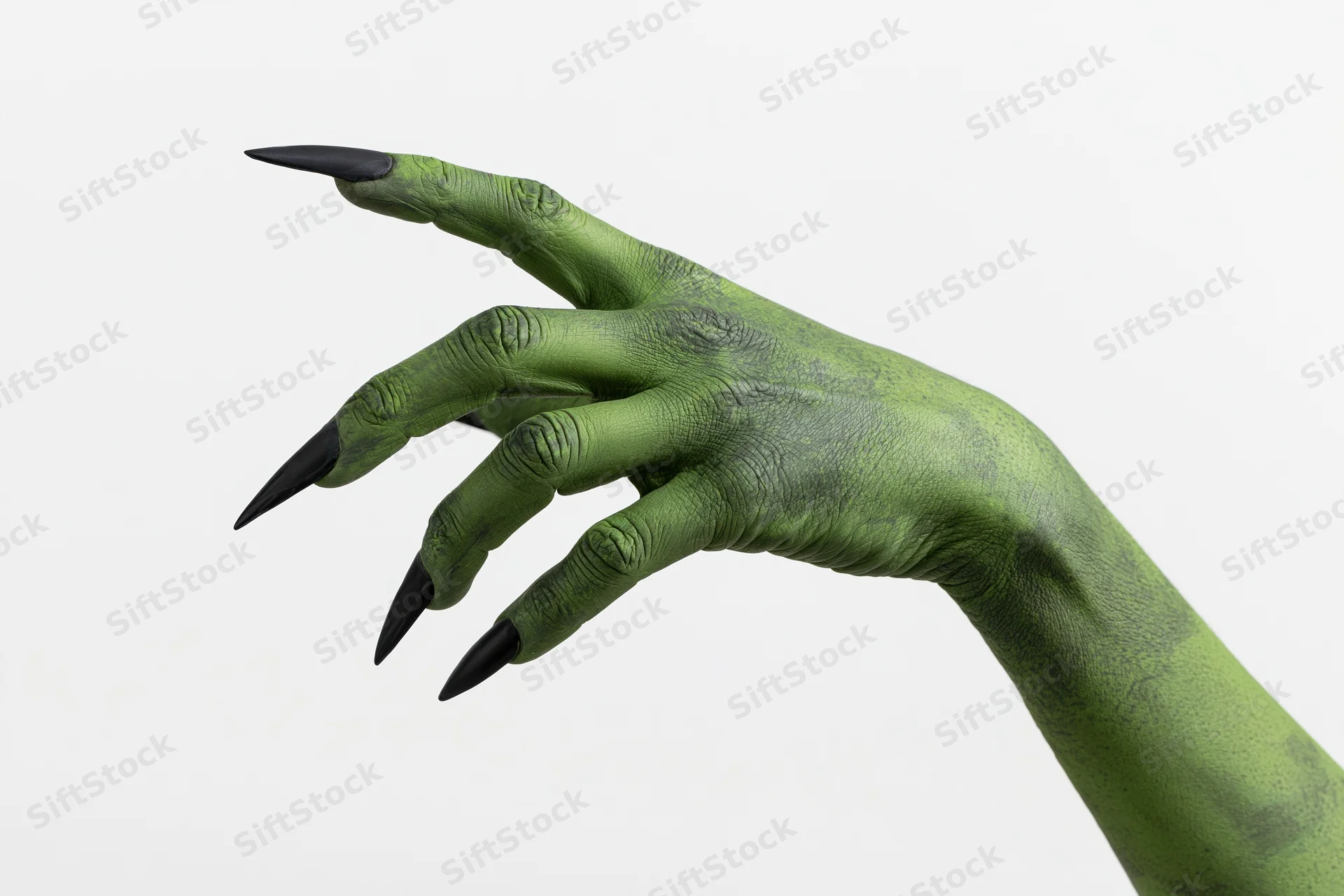 Green-painted hand with long sharp black nails reaching out against white background