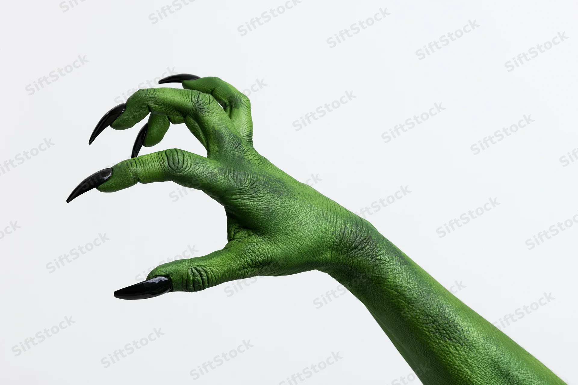 Green-painted hand with black claws extended against white background