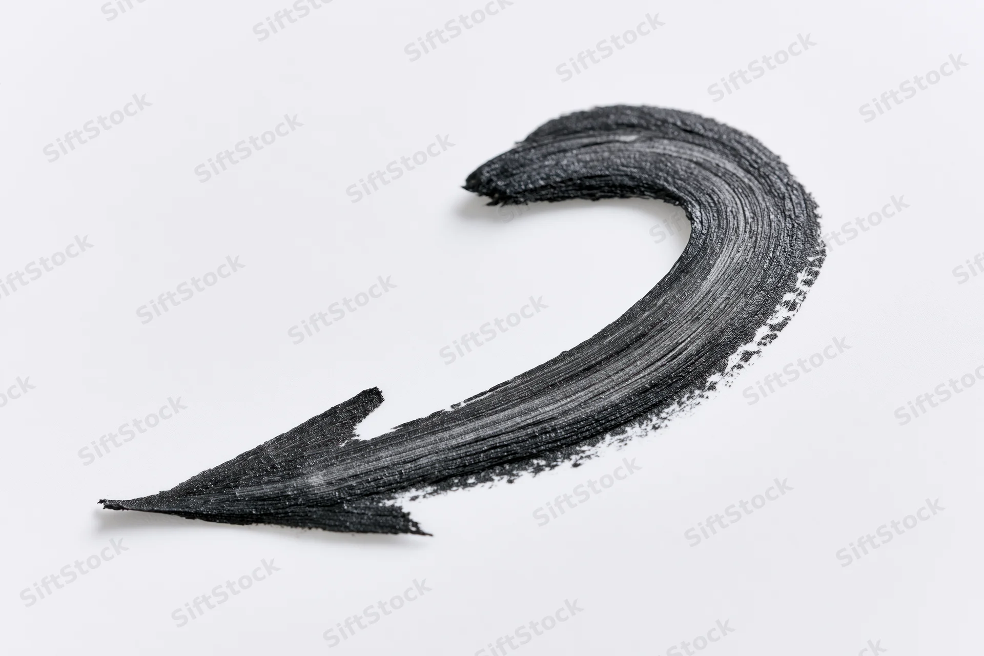Curved black brushstroke arrow pointing downward left on white background