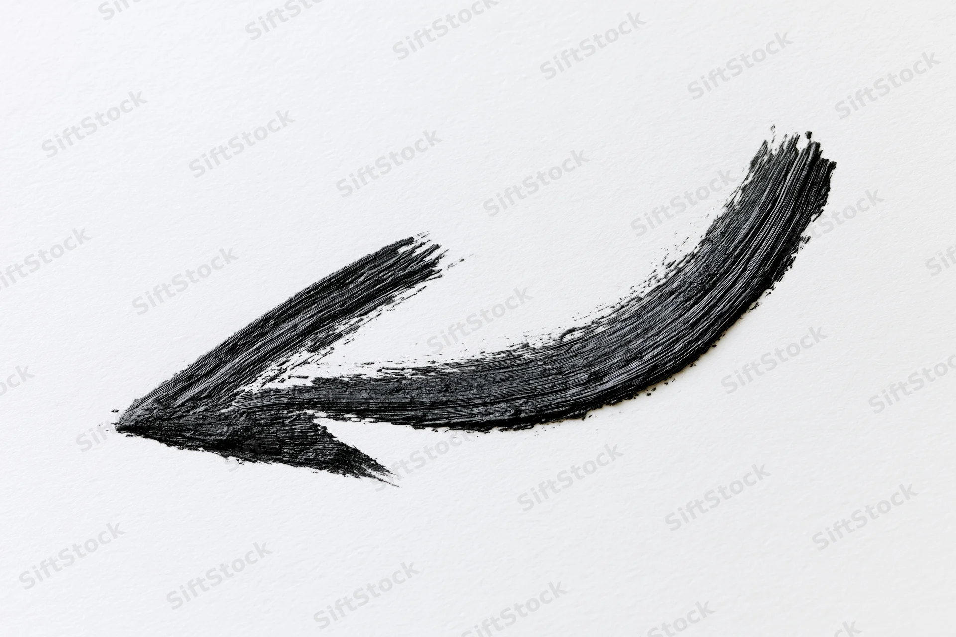 Hand-drawn curved arrow pointing downward-left on white paper