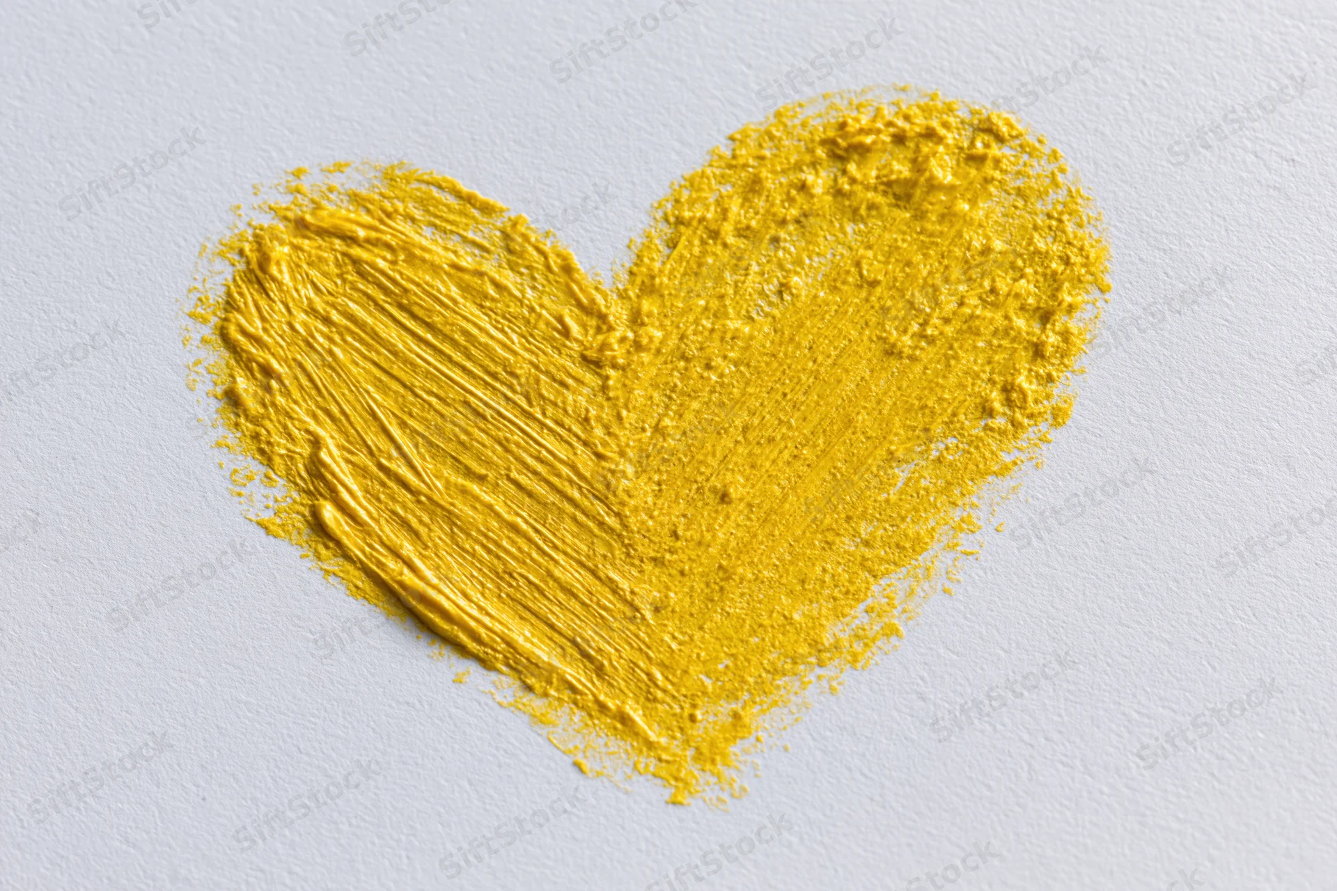 Yellow wax crayon heart drawn on white paper