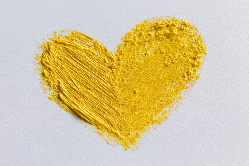 Yellow wax crayon heart drawn on white paper