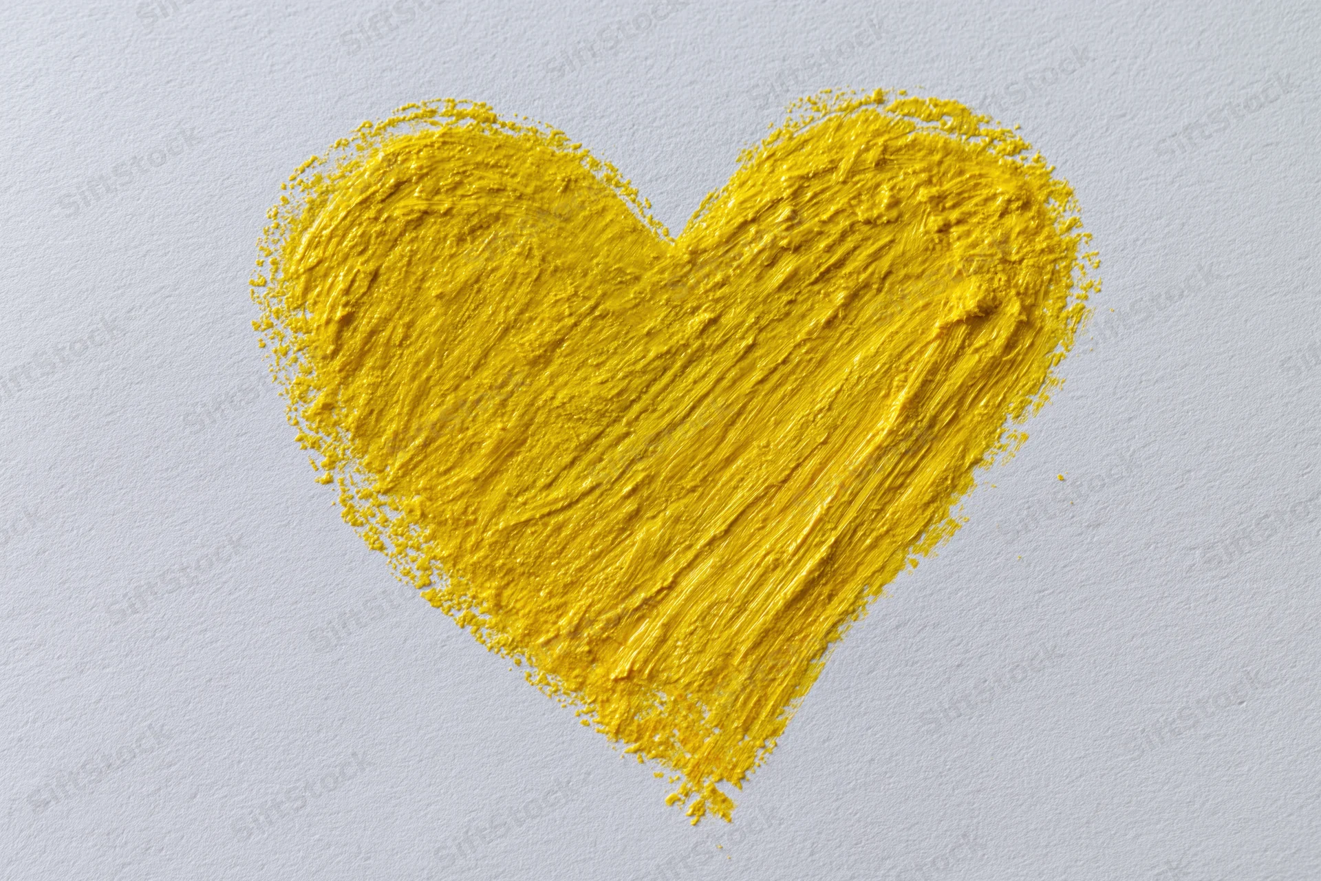 Yellow heart shape drawn with wax crayon on white paper