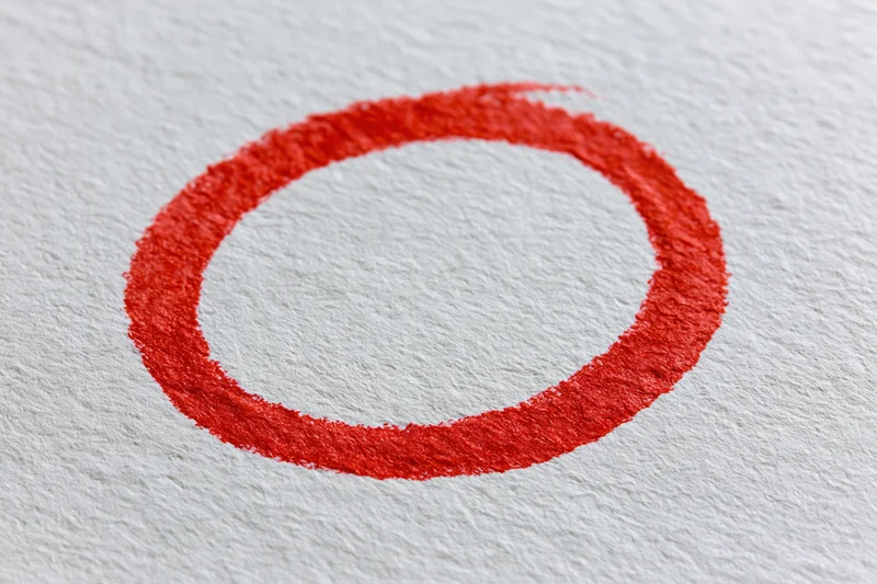 Hand-drawn red marker circle on textured white paper