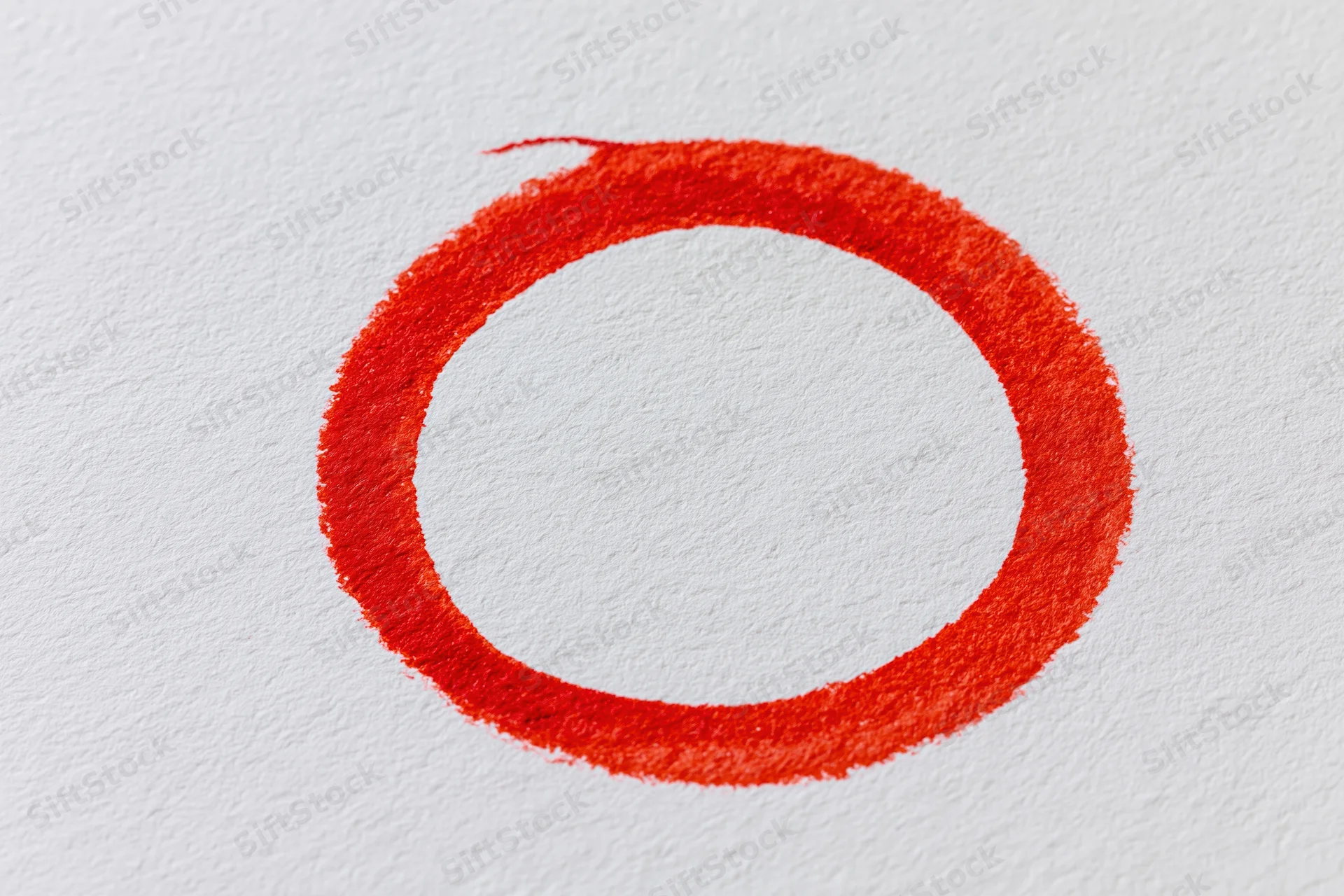 Hand-drawn red marker circle on white paper