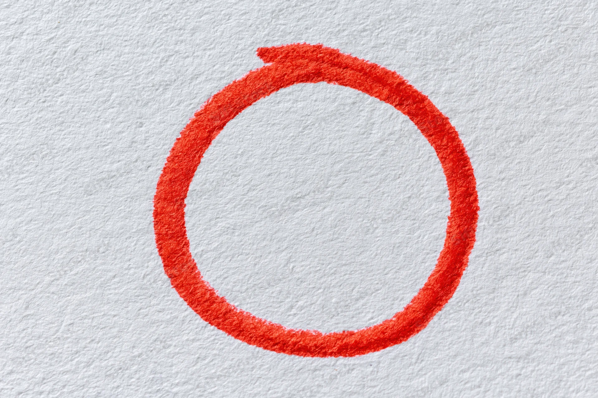 Hand-drawn red marker circle on white textured paper