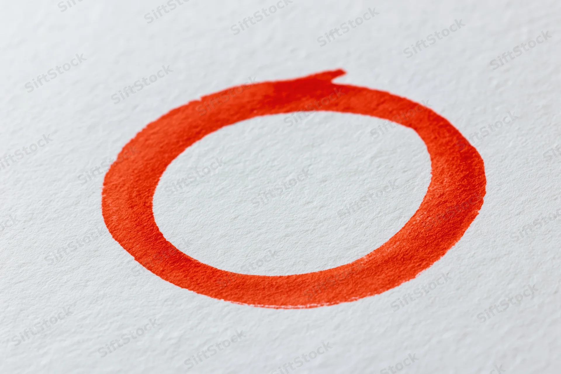Hand-drawn red marker circle on white textured paper