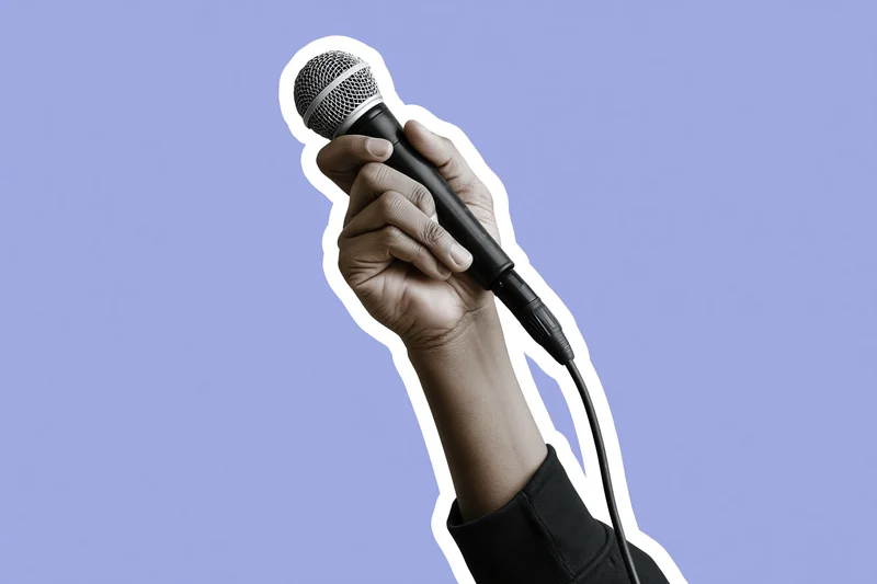 Hand gripping a wired microphone raised upward against a purple background