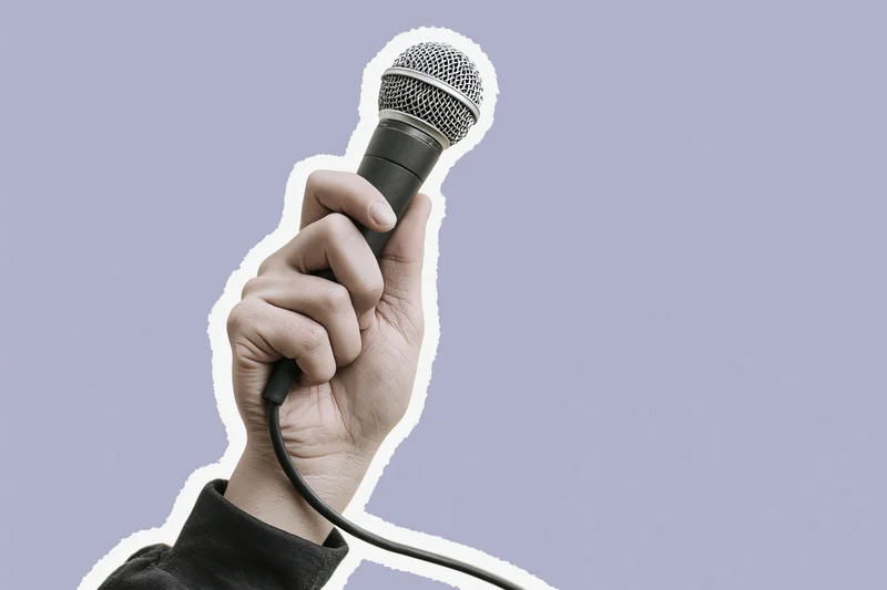 Hand gripping a wired microphone raised upward against a lavender background