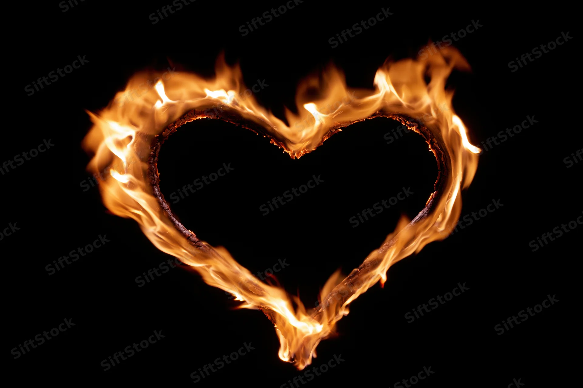 Heart-shaped flame burning against black background