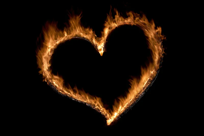Heart-shaped flame outline burning against black background