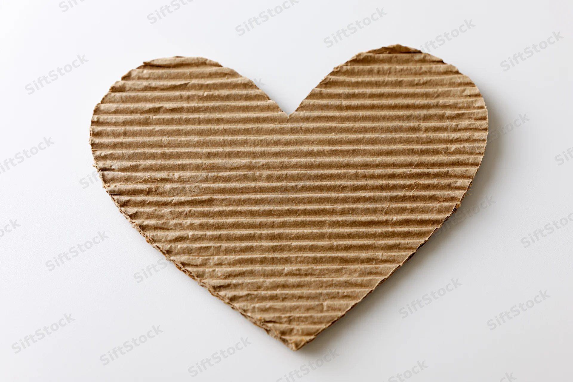 Heart-shaped corrugated kraft cardboard cutout on white background
