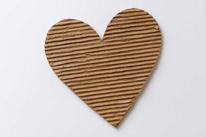 Heart-shaped corrugated kraft cardboard cutout on white background