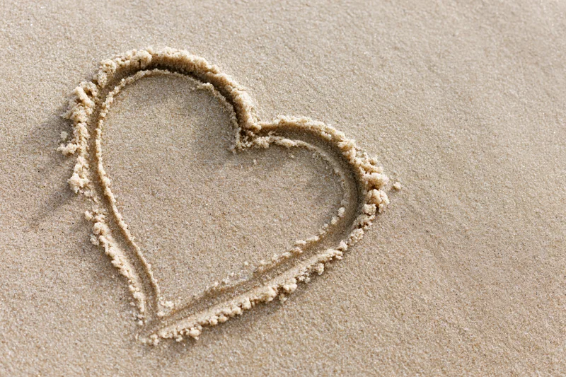 Heart shape drawn in wet sand on a beach