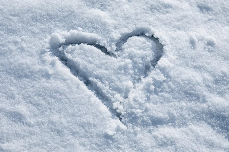 Heart shape drawn in fresh snow outdoors