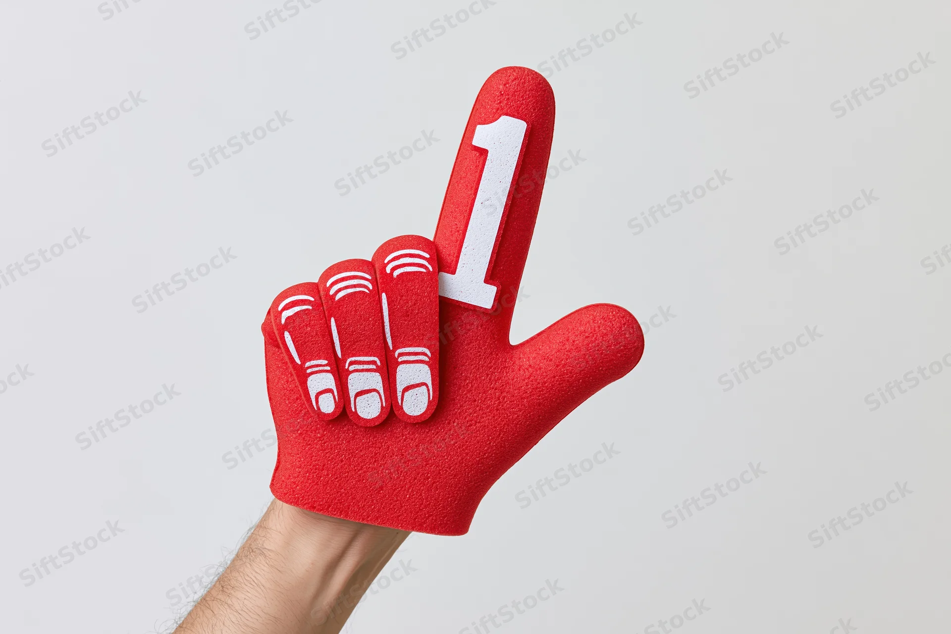 Hand wearing red foam number one glove pointing upward against white background
