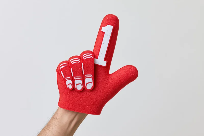 Hand wearing red foam number one glove pointing upward against white background