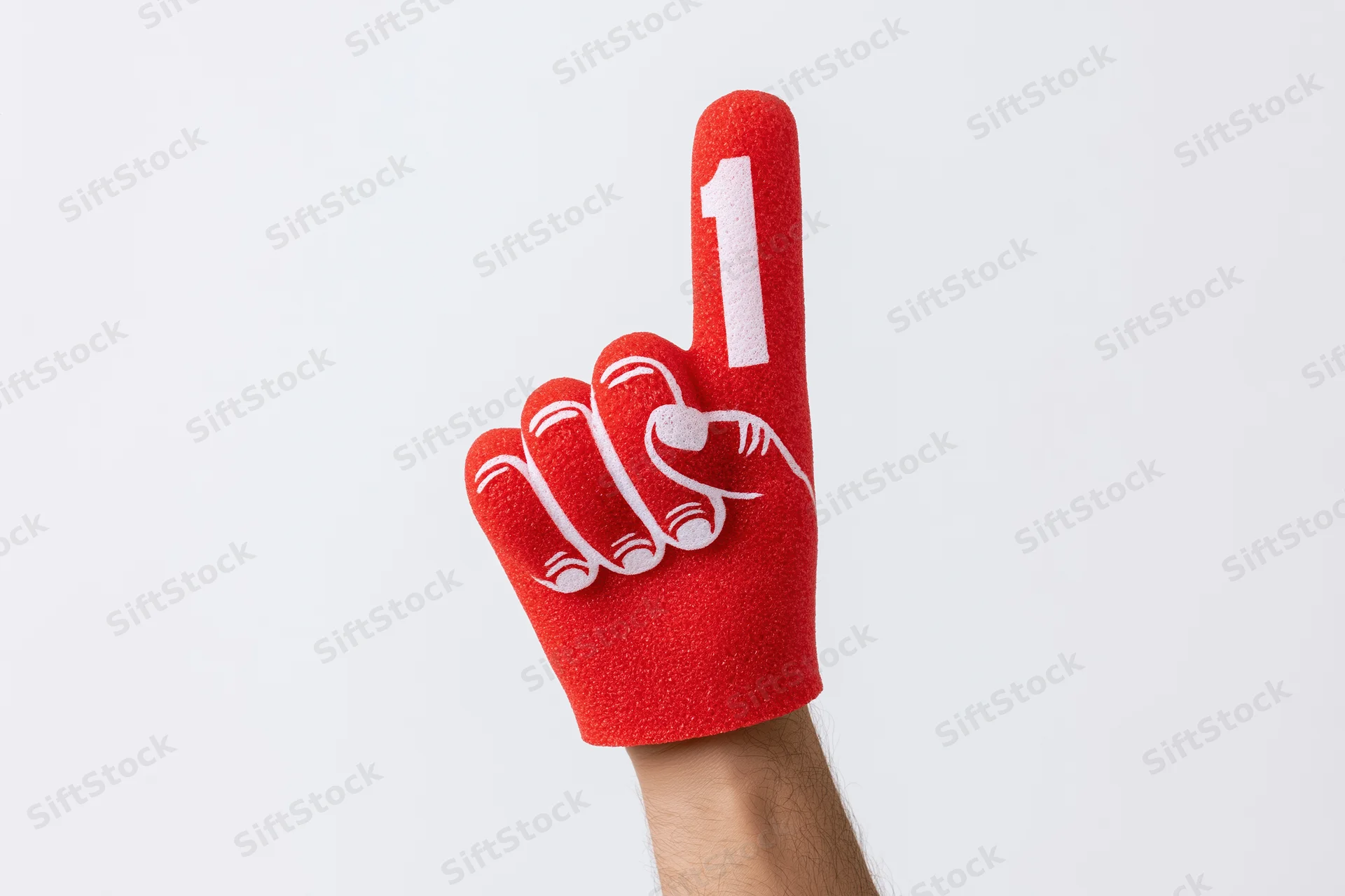 Hand wearing red foam finger with number one raised against white background